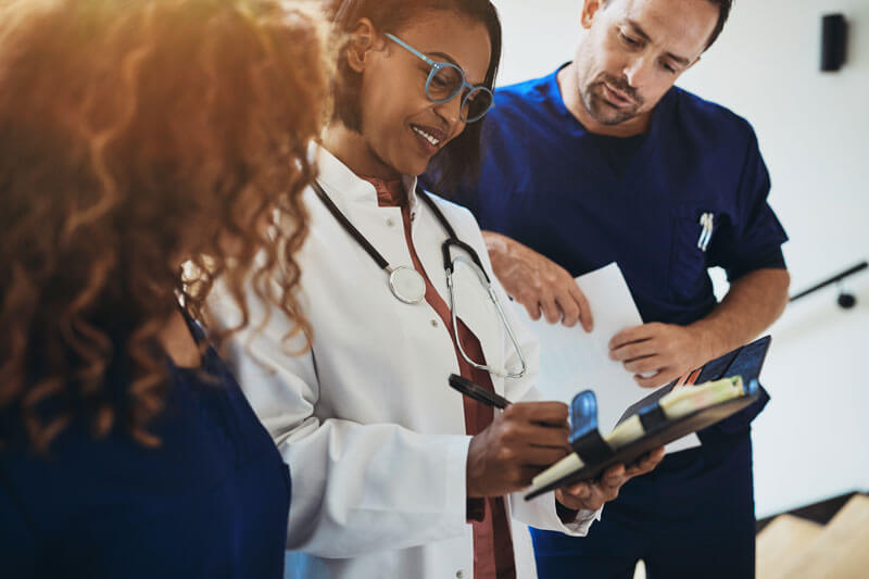 smiling doctor talking with interns in a hospital